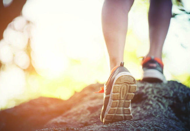 young runner woman legs close-up during running across the rock, Healthy lifestyle. Sport fitness woman.