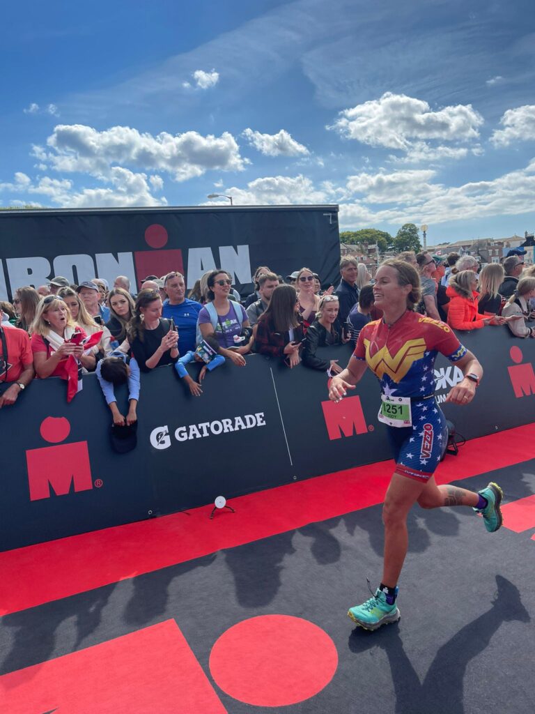 Photo of Jody Smith reaching the finish line of the Half IronMan in Weymouth 2022